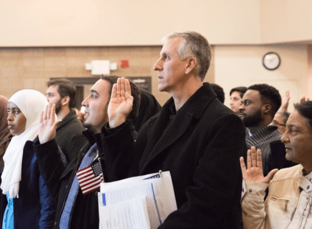 A group of new American citizens hold up their right hands during the oath ceremony.